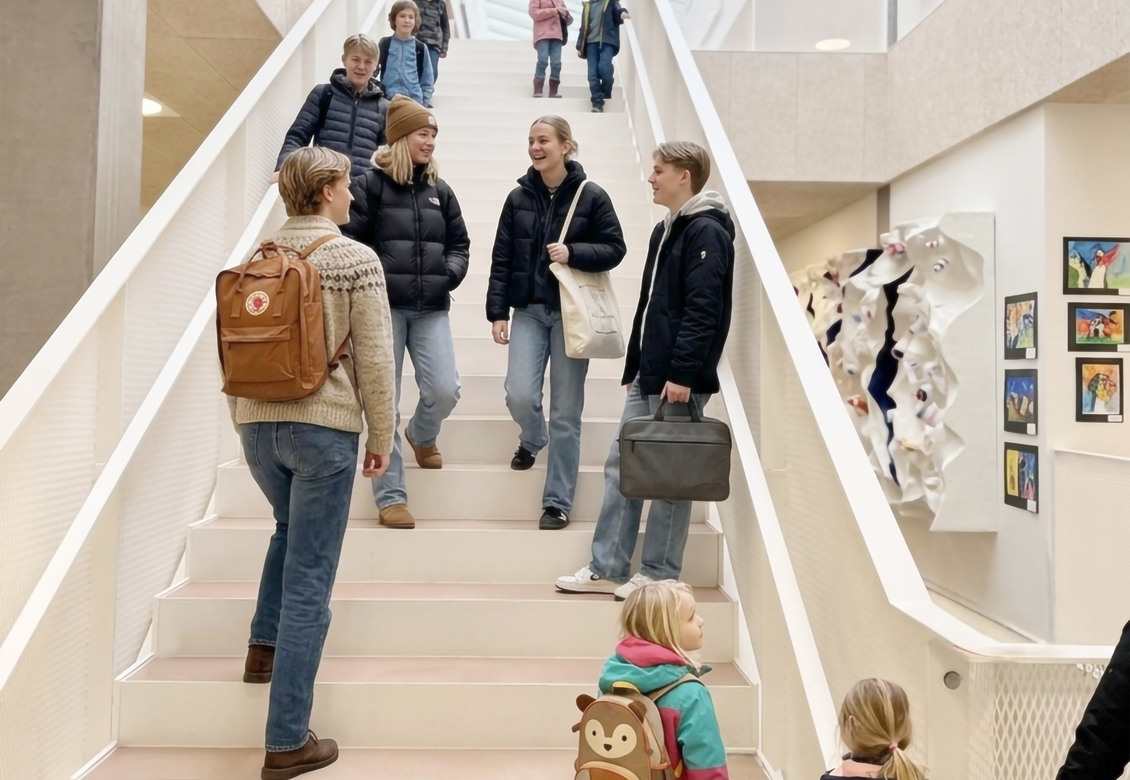 Moderne indendørs læringsmiljø på NGG i Hørsholm med dagslys, atrium og cirkelformede lamper.
