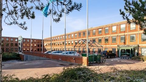 Facade af kontorejendommen Banemarksvej 50 i Brøndby med parkeringsplads og indgangsparti.