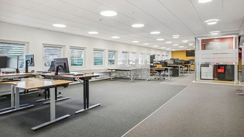 Lyst og moderne storrumskontor med hæve-sænke-borde og glaspartier på Borupvang 2 i Ballerup.