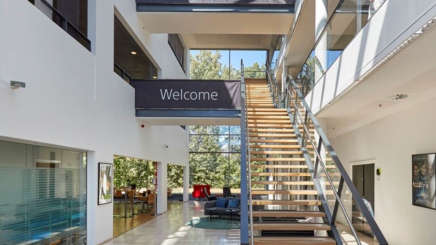 Lyst og moderne indgangsparti med atrium og trappe i kontorejendommen Industriparken 29 i Ballerup.